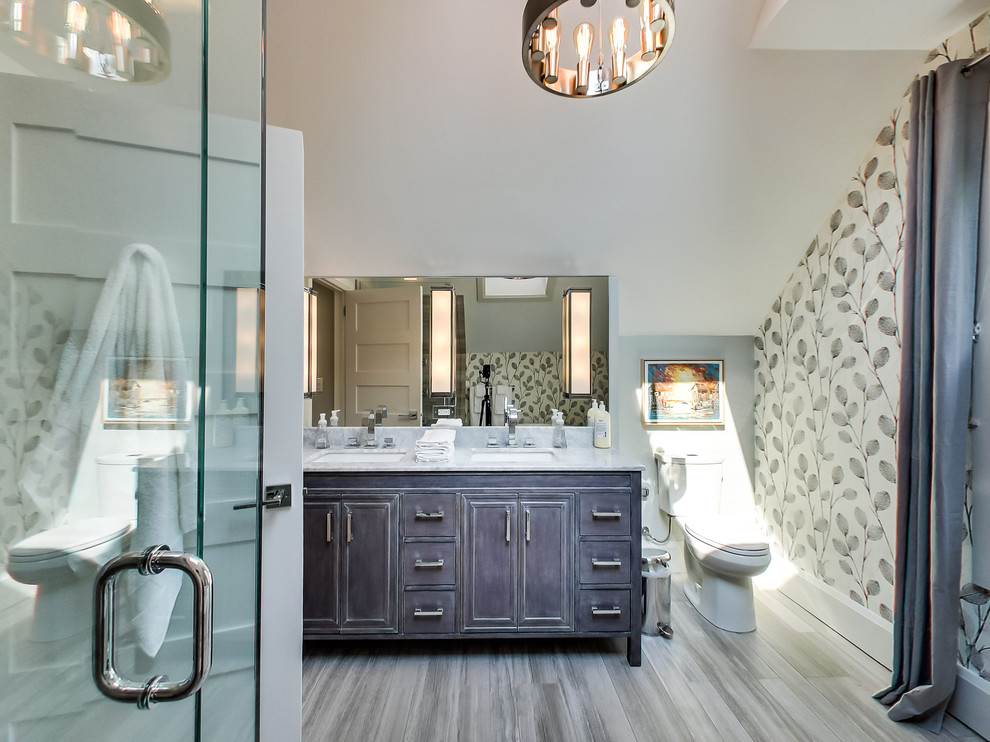Large transitional master gray tile and limestone tile limestone floor and gray floor freestanding bathtub photo in Toronto with furniture-like cabinets, gray cabinets, a two-piece toilet, white walls, an undermount sink, quartz countertops and a hinged shower door