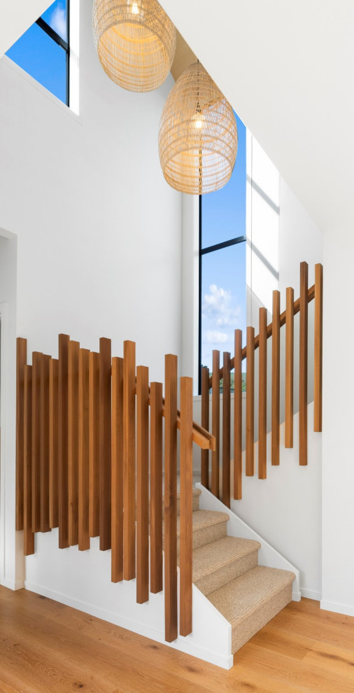 Idées déco pour un escalier contemporain en L de taille moyenne avec des marches en moquette, un garde-corps en bois et des contremarches en bois.