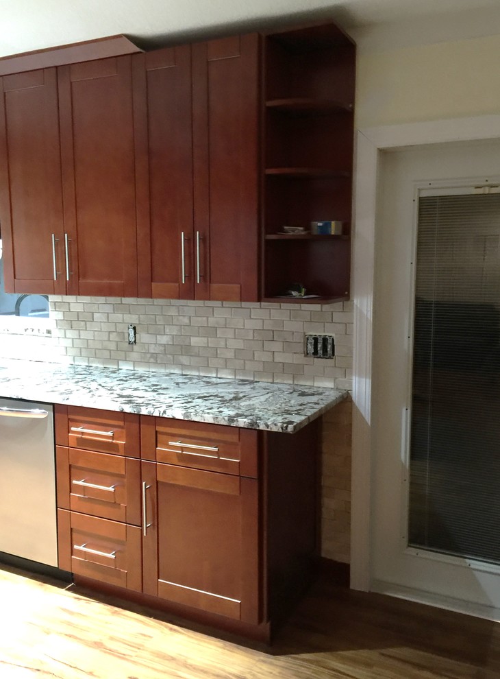 Photo of a small transitional galley eat-in kitchen in Miami with shaker cabinets, brown cabinets, marble benchtops, beige splashback, stone tile splashback, stainless steel appliances, vinyl floors, no island and a double-bowl sink.