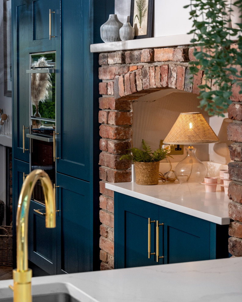 Mittelgroße Moderne Küche in L-Form mit Schrankfronten im Shaker-Stil, blauen Schränken, Granit-Arbeitsplatte, Küchenrückwand in Weiß, Kücheninsel und weißer Arbeitsplatte in Sonstige
