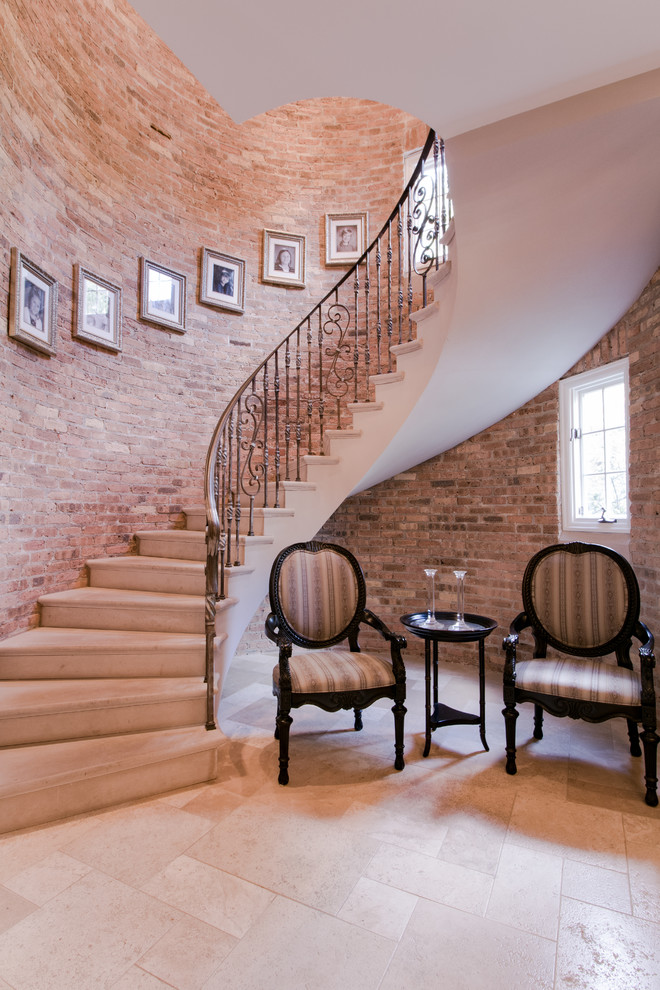 Inspiration for a large eclectic limestone curved staircase in Chicago with limestone risers and metal railing.