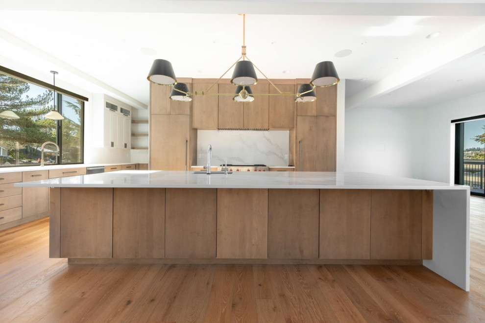 Example of a large transitional light wood floor and brown floor open concept kitchen design in Seattle with an undermount sink, flat-panel cabinets, medium tone wood cabinets, quartz countertops, quartz backsplash, paneled appliances and an island
