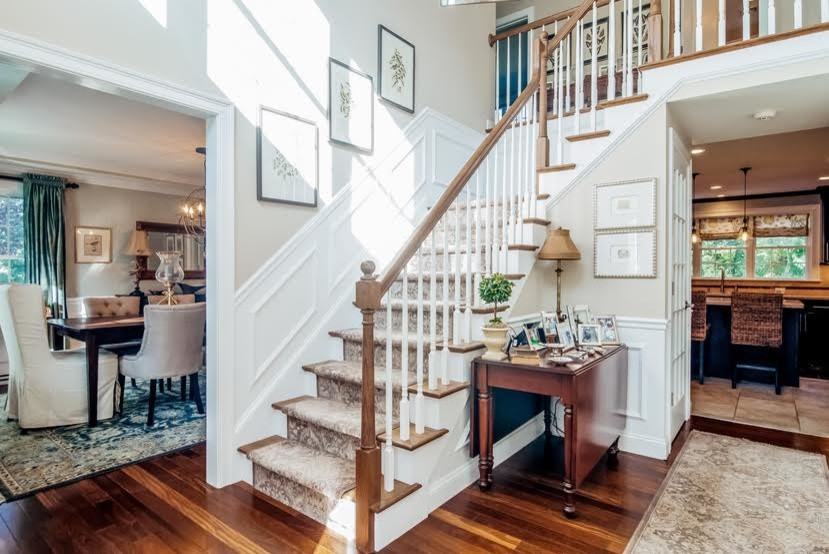 Photo of a mid-sized traditional foyer in Boston with beige walls, dark hardwood floors, a single front door, a light wood front door and brown floor.