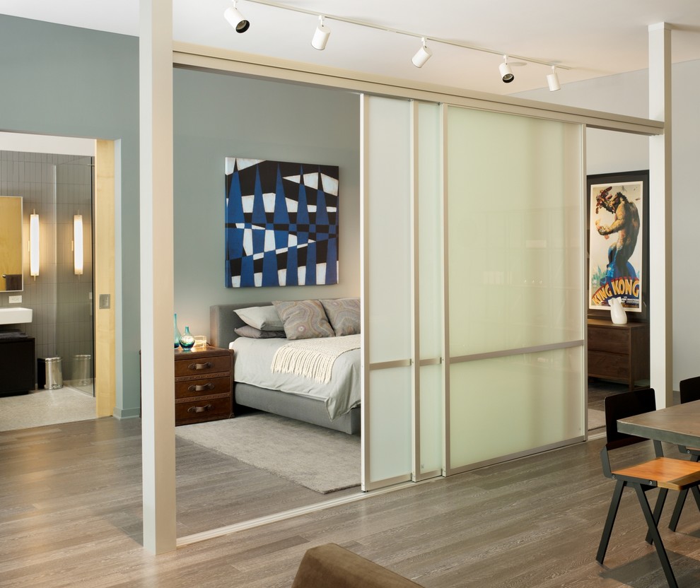 Design ideas for an industrial bedroom in Los Angeles with grey walls and medium hardwood floors.