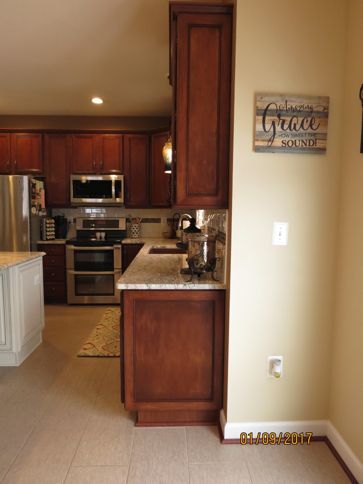 Mid-sized transitional l-shaped ceramic tile eat-in kitchen photo with an undermount sink, raised-panel cabinets, distressed cabinets, granite countertops, white backsplash, porcelain backsplash, stainless steel appliances and an island