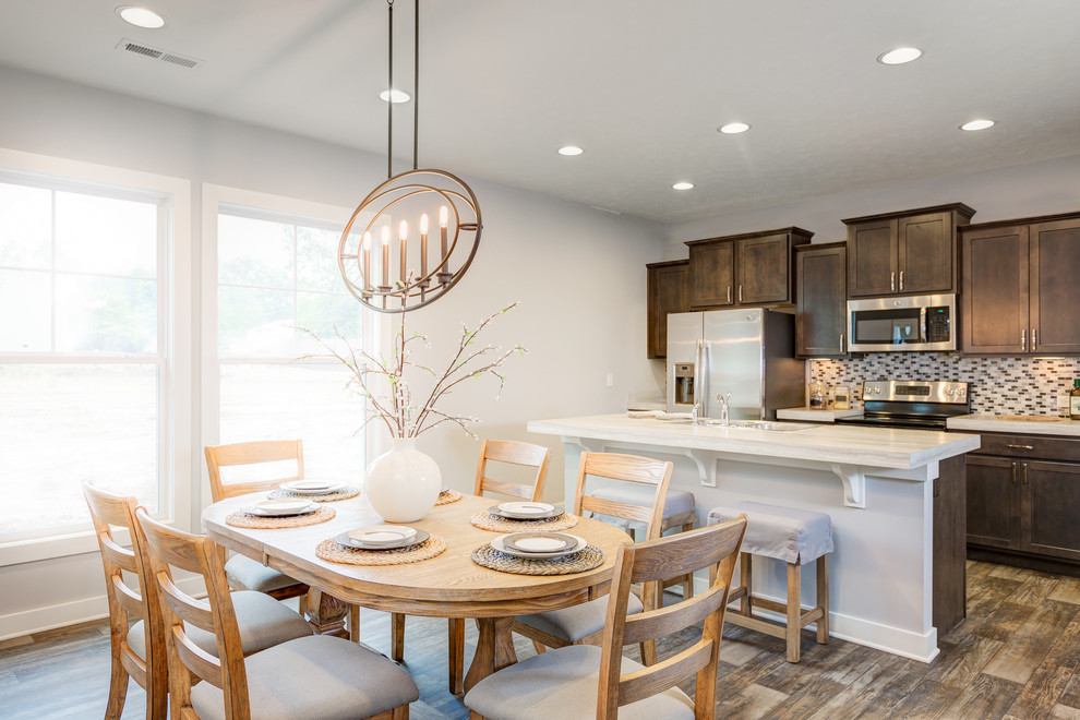 Inspiration for a mid-sized transitional galley kitchen remodel with a double-bowl sink, recessed-panel cabinets, dark wood cabinets, laminate countertops, multicolored backsplash, ceramic backsplash, stainless steel appliances and an island