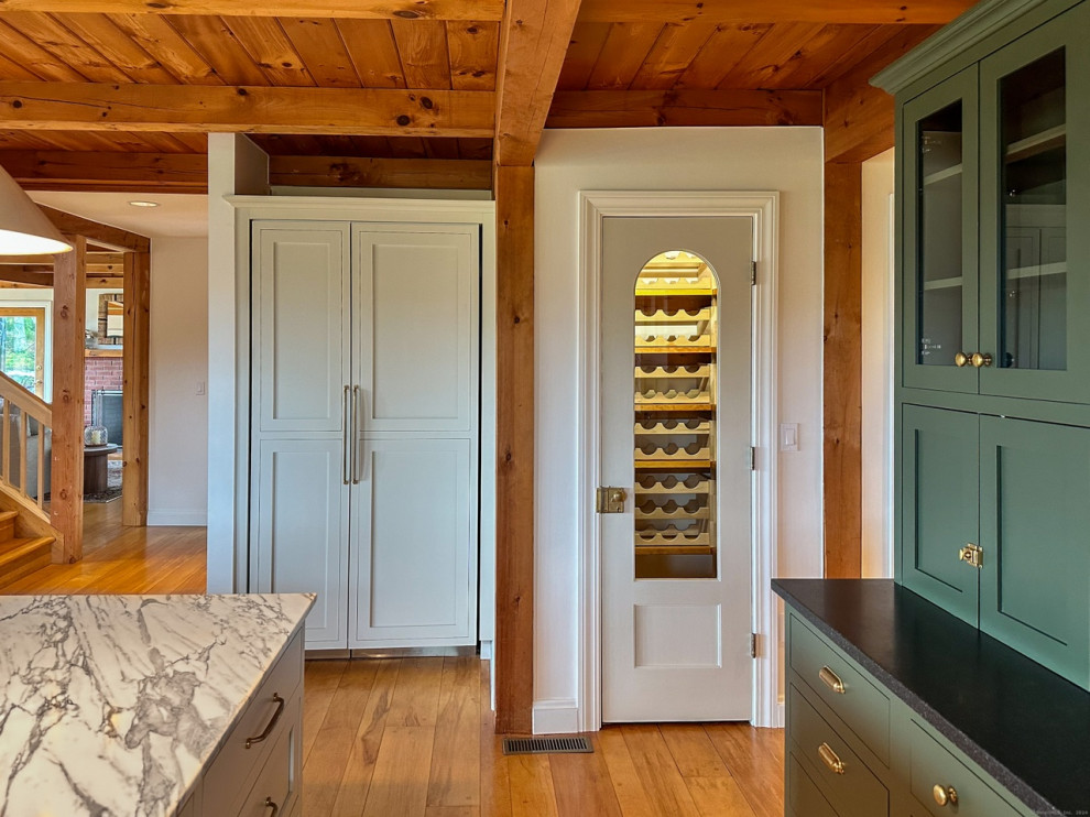 Inspiration for a mid-sized rustic u-shaped medium tone wood floor, brown floor and wood ceiling eat-in kitchen remodel in Boston with a farmhouse sink, recessed-panel cabinets, green cabinets, granite countertops, white backsplash, marble backsplash, stainless steel appliances, two islands and black countertops