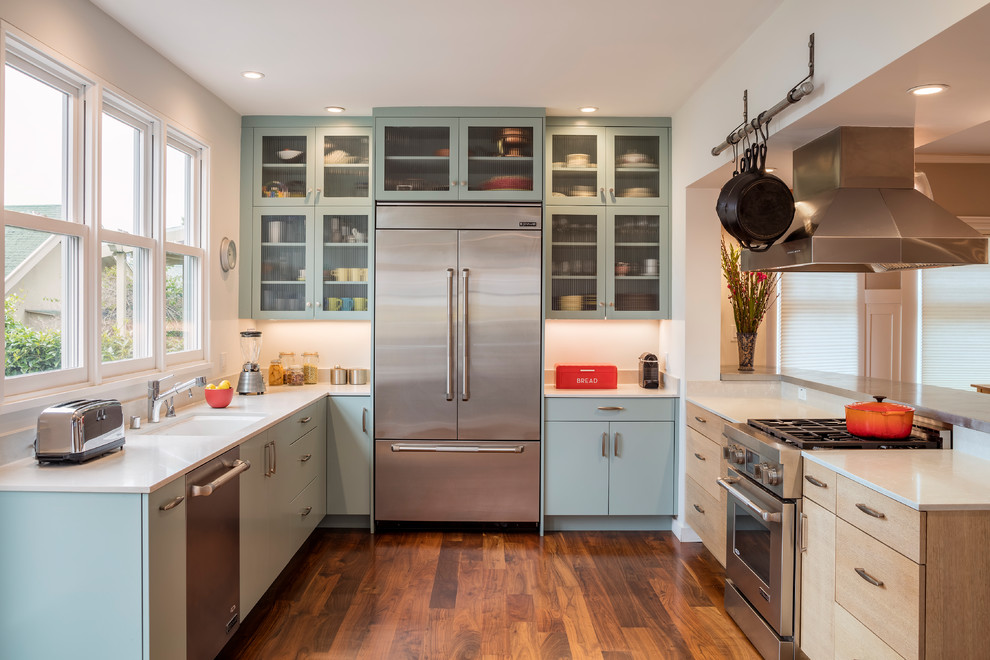 Photo of a contemporary u-shaped kitchen in San Francisco with an undermount sink, flat-panel cabinets, turquoise cabinets, stainless steel appliances, medium hardwood floors, a peninsula and brown floor.
