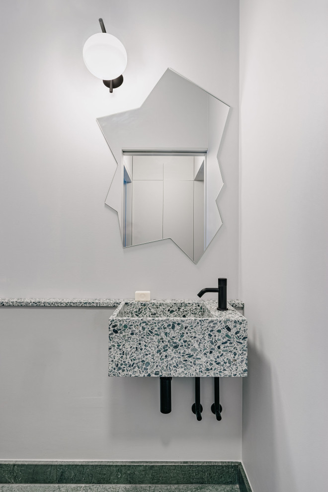 This is an example of a modern powder room in Berlin with marble floors, a wall-mount sink, terrazzo benchtops, green floor and a floating vanity.