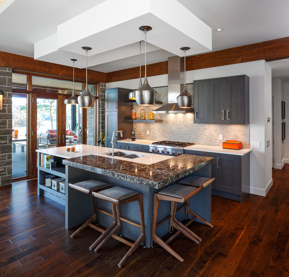 This is an example of a mid-sized contemporary eat-in kitchen in Ottawa with grey splashback, stainless steel appliances, dark hardwood floors and with island.