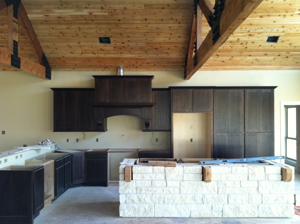 Example of a mountain style l-shaped open concept kitchen design in Houston with shaker cabinets, dark wood cabinets, granite countertops and an island