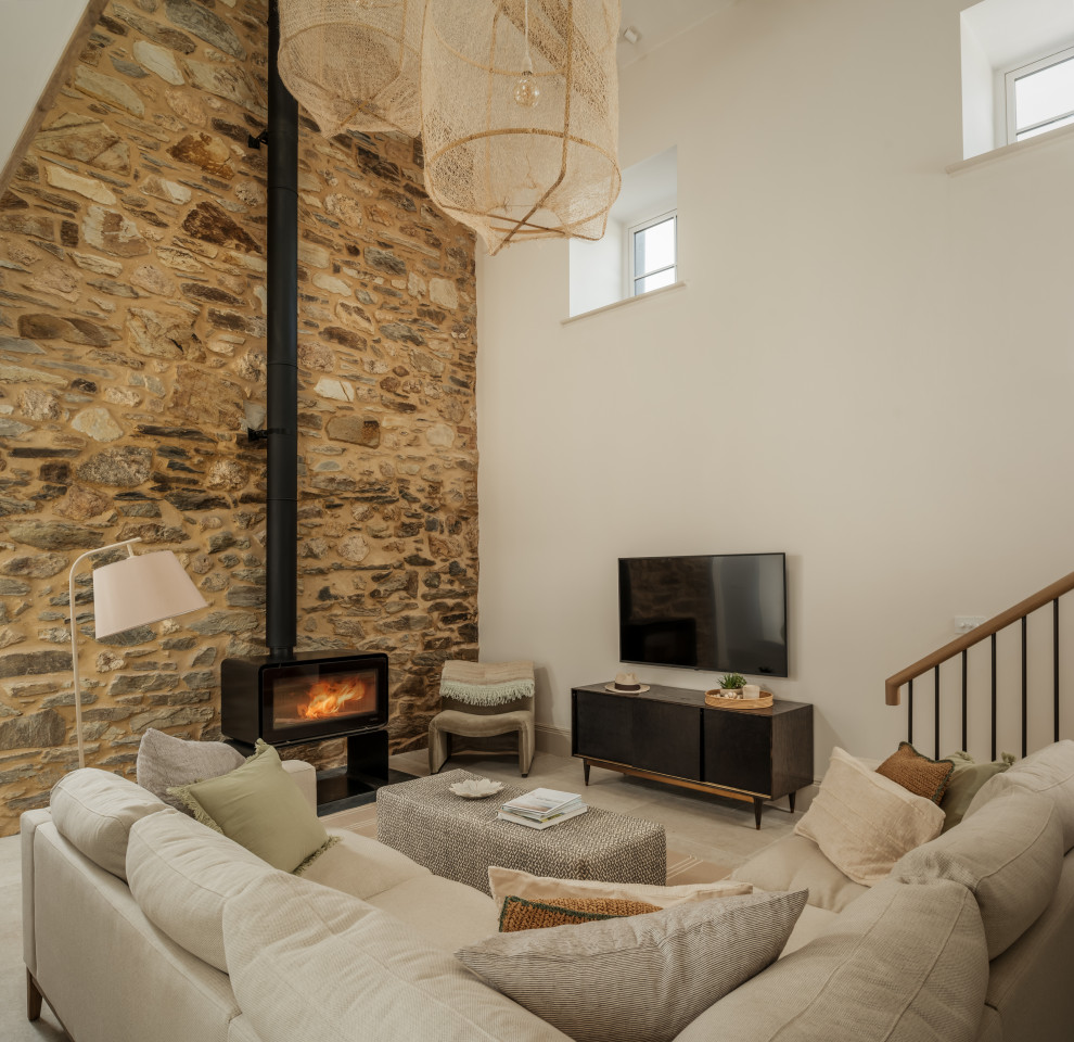 Cette image montre un très grand salon marin ouvert avec parquet clair, un poêle à bois, un manteau de cheminée en pierre, un téléviseur indépendant, un mur en parement de brique et éclairage.