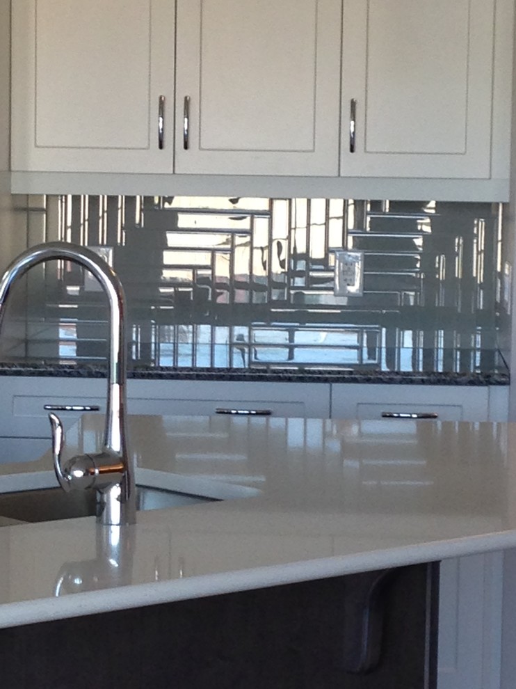 Transitional u-shaped dark wood floor open concept kitchen photo in Edmonton with a double-bowl sink, shaker cabinets, white cabinets, solid surface countertops, black backsplash, ceramic backsplash, stainless steel appliances and an island