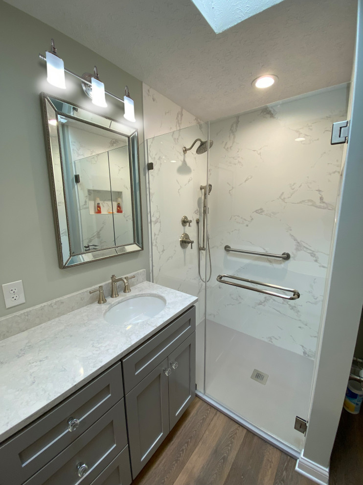 Inspiration for a mid-sized transitional master vinyl floor, brown floor and double-sink freestanding bathtub remodel in Huntington with shaker cabinets, gray cabinets, an undermount sink, quartz countertops, a hinged shower door, white countertops and a freestanding vanity
