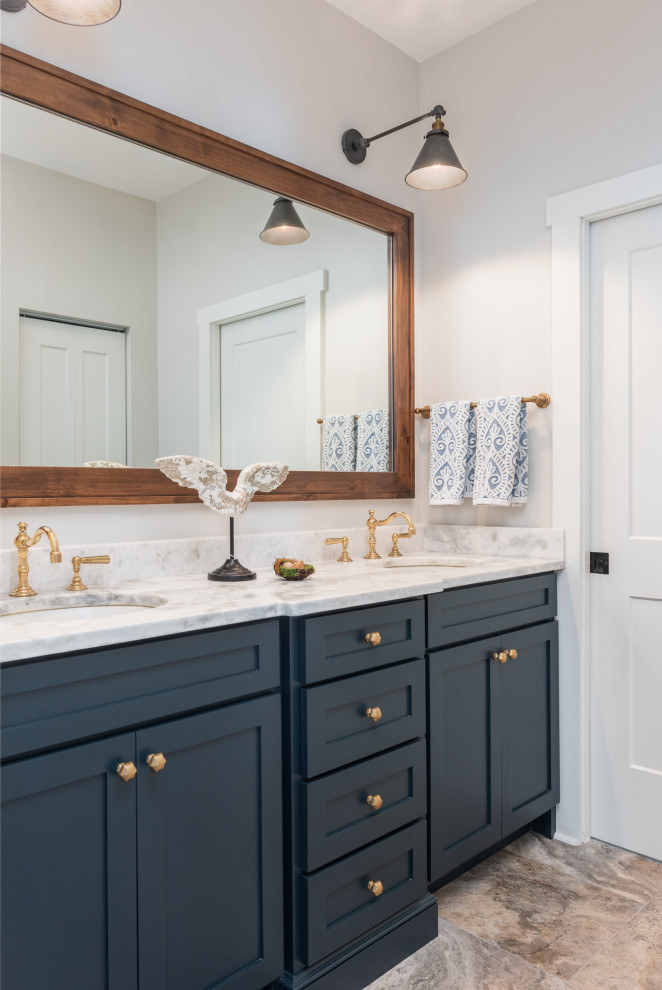 Design ideas for a mid-sized country kids bathroom in Tampa with shaker cabinets, blue cabinets, an alcove tub, a one-piece toilet, subway tile, white walls, travertine floors, an undermount sink, marble benchtops, beige floor, white benchtops, a double vanity and a built-in vanity.