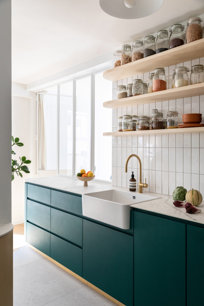 Design ideas for a mid-sized modern l-shaped open plan kitchen in Paris with a single-bowl sink, beaded inset cabinets, green cabinets, tile benchtops, white splashback, porcelain splashback, black appliances, ceramic floors, with island, grey floor and grey benchtop.