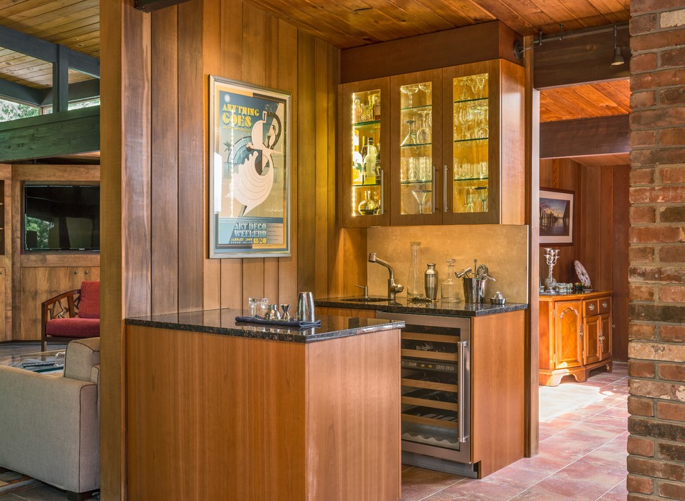 Small country galley wet bar in Boston with glass-front cabinets, medium wood cabinets and beige splashback.