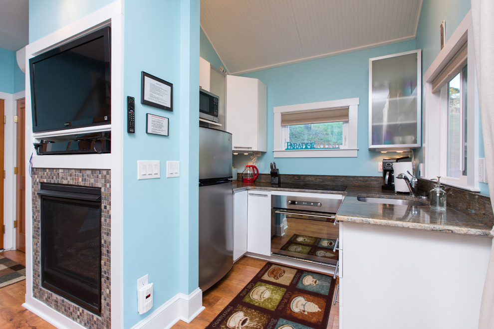 Open concept kitchen - small transitional u-shaped medium tone wood floor and brown floor open concept kitchen idea in DC Metro with an undermount sink, flat-panel cabinets, white cabinets, granite countertops, stainless steel appliances and no island