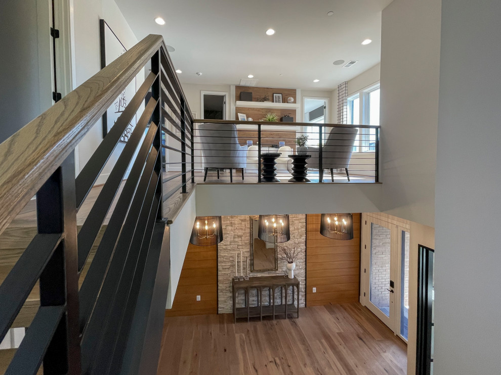 Источник вдохновения для домашнего уюта: большая прямая лестница в современном стиле с деревянными ступенями, перилами из смешанных материалов и панелями на части стены