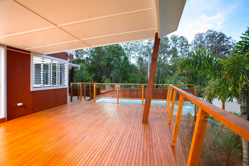 Large contemporary backyard deck in Brisbane with a roof extension.