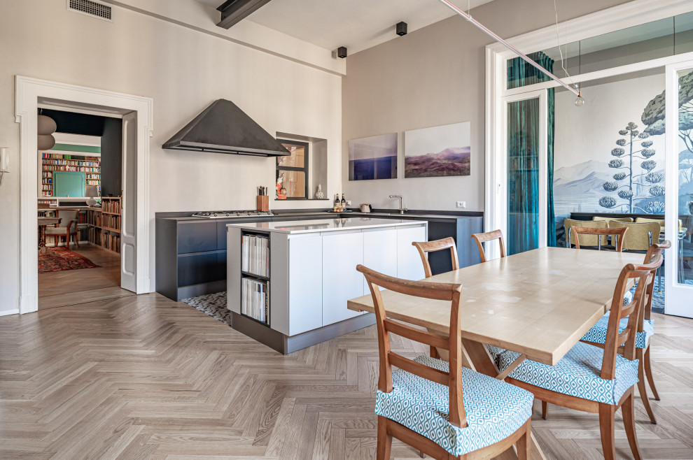 Inspiration for an expansive eclectic l-shaped separate kitchen in Milan with a double-bowl sink, flat-panel cabinets, beige cabinets, quartz benchtops, beige splashback, stainless steel appliances, ceramic floors, with island, multi-coloured floor, black benchtop and exposed beam.