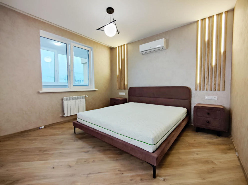 Mid-sized contemporary master bedroom in Moscow with beige walls, laminate floors, beige floor and wallpaper.