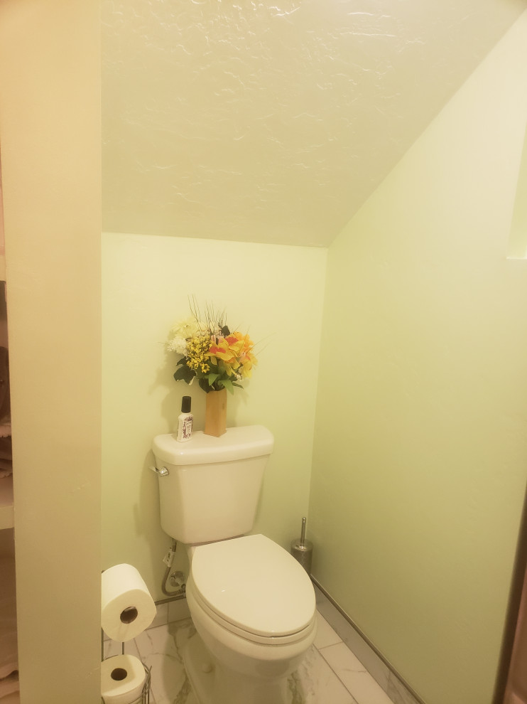 Пример оригинального дизайна: маленький туалет в современном стиле с фасадами с выступающей филенкой, белыми фасадами, раздельным унитазом, керамической плиткой, желтыми стенами, полом из керамической плитки, монолитной раковиной, белым полом, напольной тумбой и бежевой плиткой для на участке и в саду