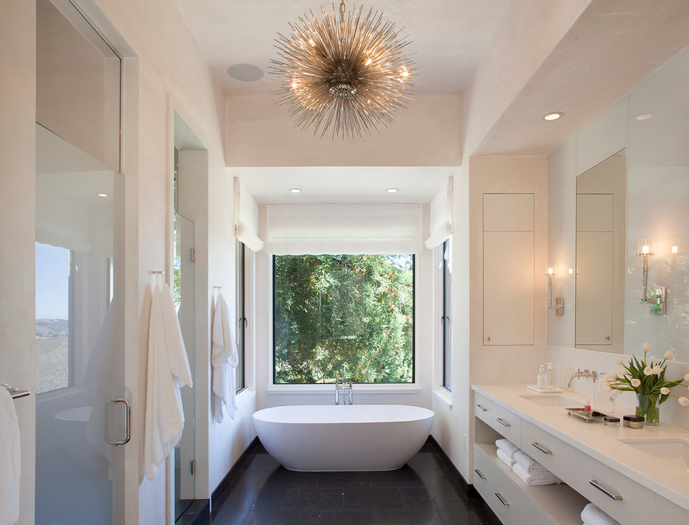 This is an example of a contemporary master bathroom in San Francisco with an undermount sink, beige cabinets, a freestanding tub and beige walls.