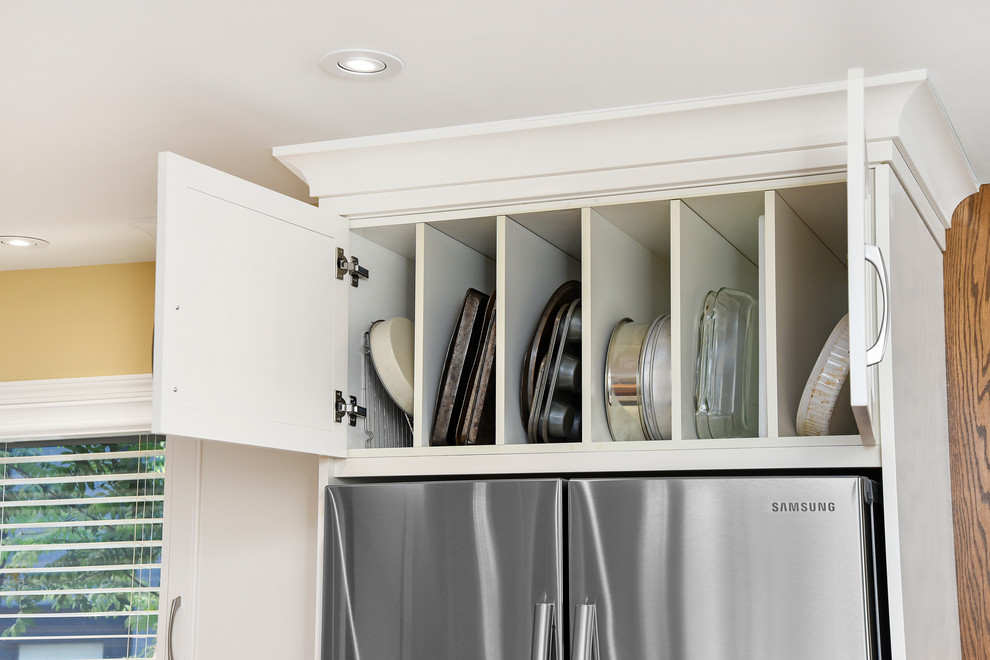 Inspiration for a mid-sized transitional l-shaped medium tone wood floor and beige floor eat-in kitchen remodel in Calgary with an undermount sink, recessed-panel cabinets, white cabinets, quartz countertops, gray backsplash, glass tile backsplash, stainless steel appliances and an island