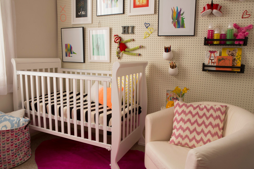 This is an example of a small contemporary nursery for girls in Sydney with white walls and carpet.
