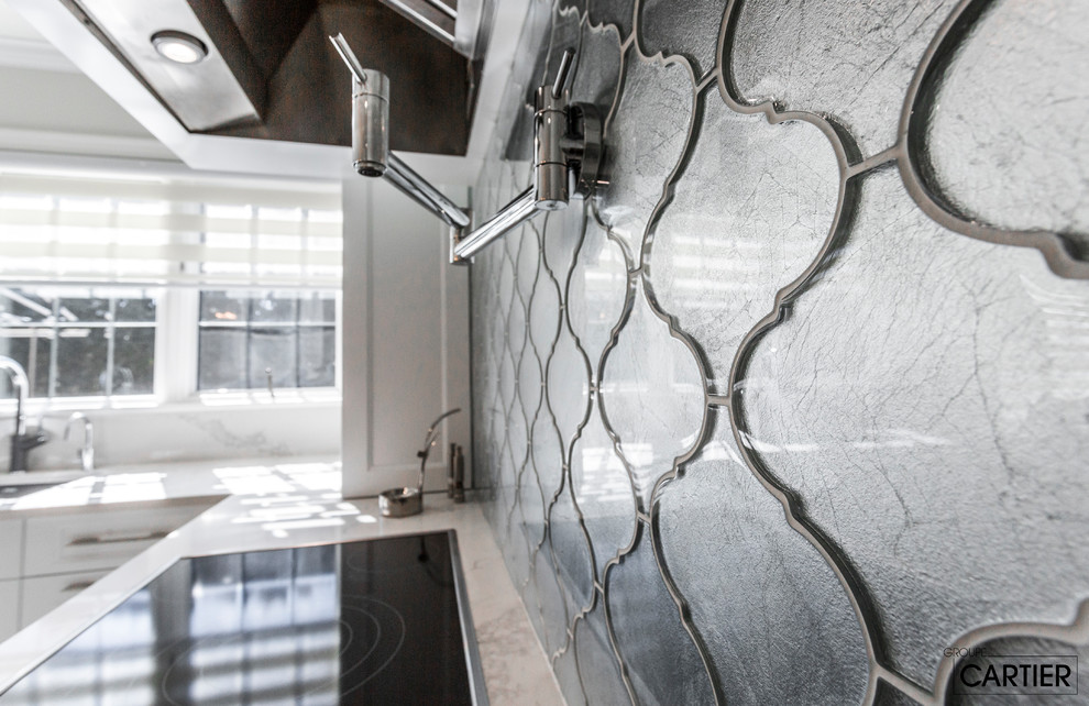Inspiration for a huge transitional l-shaped marble floor eat-in kitchen remodel in Montreal with an undermount sink, shaker cabinets, white cabinets, quartzite countertops, gray backsplash, glass tile backsplash, paneled appliances and an island