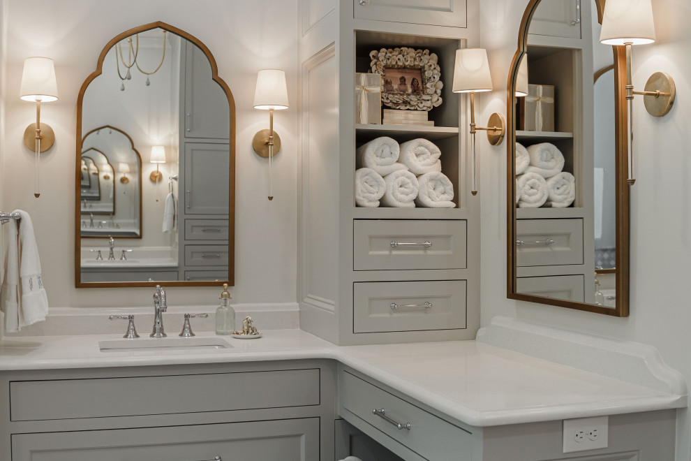 This is an example of a large transitional master bathroom in Other with beaded inset cabinets, grey cabinets, a freestanding tub, a corner shower, gray tile, porcelain tile, white walls, porcelain floors, an undermount sink, quartzite benchtops, grey floor, a hinged shower door, white benchtops, an enclosed toilet, a double vanity and a built-in vanity.