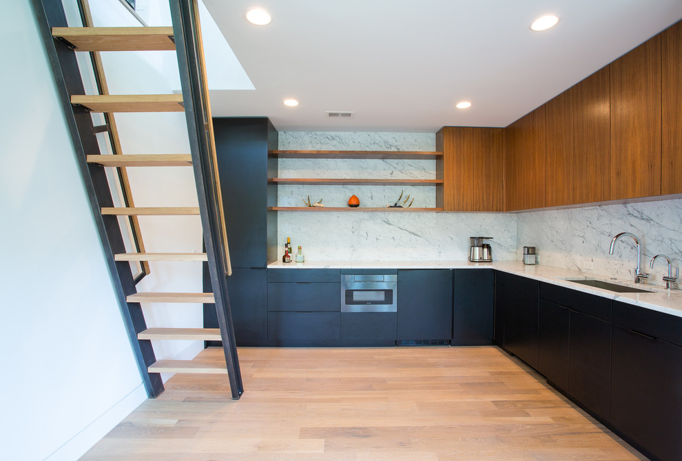 Inspiration for a mid-sized modern l-shaped kitchen in DC Metro with an undermount sink, flat-panel cabinets, black cabinets, white splashback, stone slab splashback, panelled appliances, light hardwood floors, no island, brown floor and white benchtop.