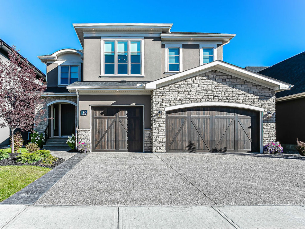 Inspiration for a transitional beige two-story stucco and board and batten gable roof remodel in Calgary with a shingle roof and a black roof