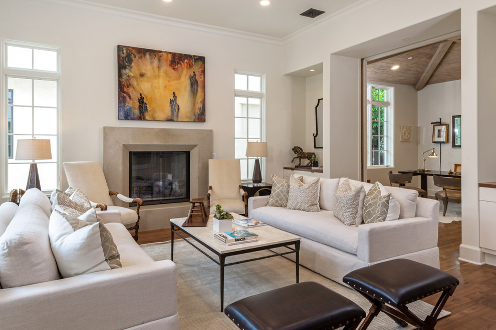 This is an example of a mediterranean enclosed living room in Los Angeles with white walls, dark hardwood floors, a standard fireplace and no tv.