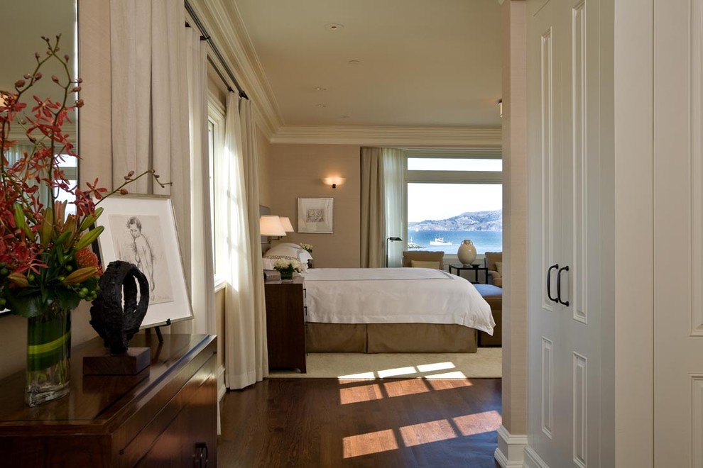Photo of a contemporary bedroom in San Francisco with beige walls, dark hardwood floors and brown floor.