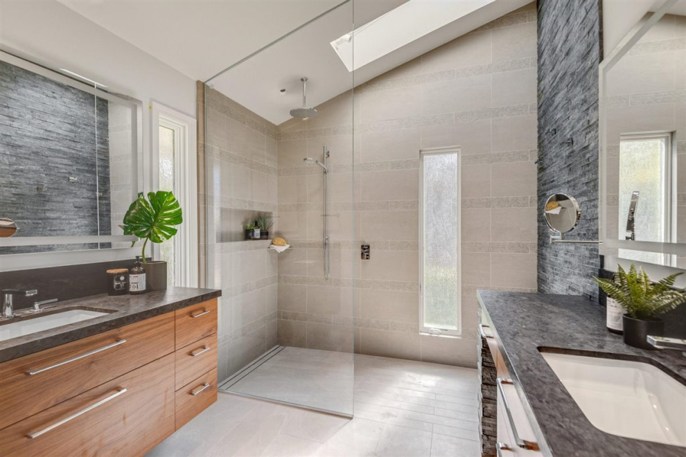 Photo of a mid-sized midcentury master bathroom in San Francisco with flat-panel cabinets, medium wood cabinets, a curbless shower, a one-piece toilet, gray tile, an open shower, vaulted, stone tile, grey walls, porcelain floors, an undermount sink, engineered quartz benchtops, grey floor, grey benchtops, a double vanity and a built-in vanity.