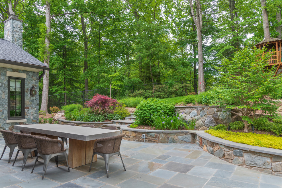 The existing curved stone walls were repurposed to enhance an expansive new dining patio and terraced perennial plantings.