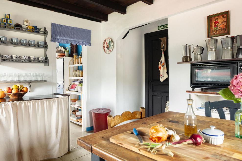 Large eclectic l-shaped separate kitchen in Bilbao with a double-bowl sink, open cabinets, blue cabinets, wood benchtops, white appliances, ceramic floors, with island, beige floor and brown benchtop.