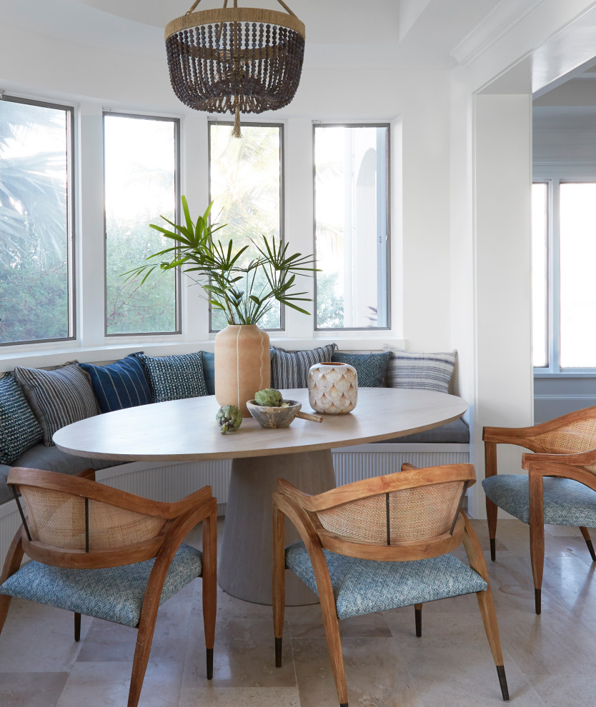 Photo of a beach style dining room in Miami with white walls and beige floor.