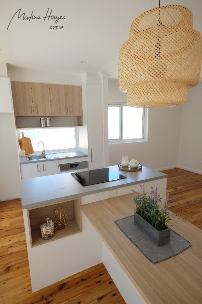 Small contemporary galley eat-in kitchen in Sydney with flat-panel cabinets, light wood cabinets, laminate benchtops, window splashback, stainless steel appliances, multiple islands, grey benchtop, a drop-in sink, medium hardwood floors and brown floor.