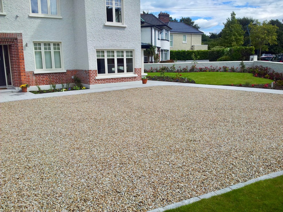 Inspiration for a large contemporary front yard full sun driveway for summer in Dublin with a garden path, natural stone pavers and a stone fence.