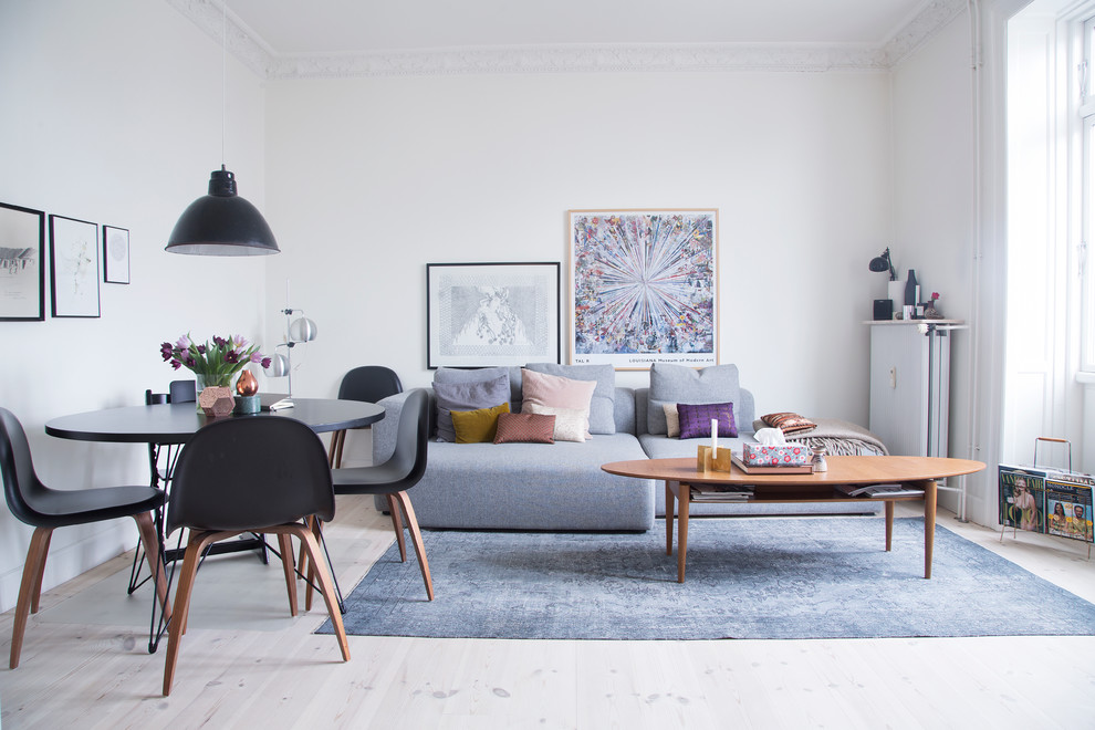 Mid-sized scandinavian formal enclosed living room in Copenhagen with white walls, light hardwood floors and no tv.