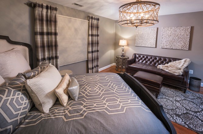Foto de habitación de invitados tradicional renovada de tamaño medio sin chimenea con paredes grises, suelo de madera en tonos medios y suelo marrón