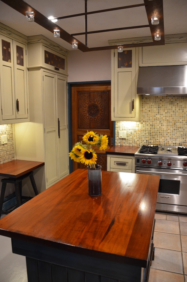 Mid-sized mountain style u-shaped ceramic tile eat-in kitchen photo with a farmhouse sink, recessed-panel cabinets, beige cabinets, wood countertops, multicolored backsplash, stone tile backsplash, stainless steel appliances and an island