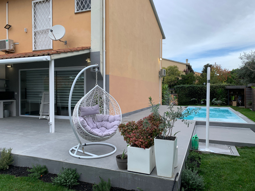 Photo of a medium sized contemporary back rectangular above ground swimming pool in Rome with a bbq area and natural stone paving.