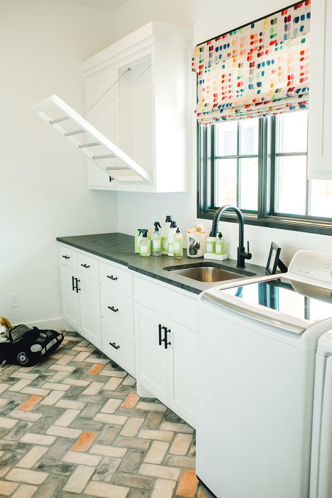 Design ideas for a transitional single-wall dedicated laundry room in Austin with an undermount sink, shaker cabinets, white cabinets, granite benchtops, white walls, a side-by-side washer and dryer, multi-coloured floor and grey benchtop.