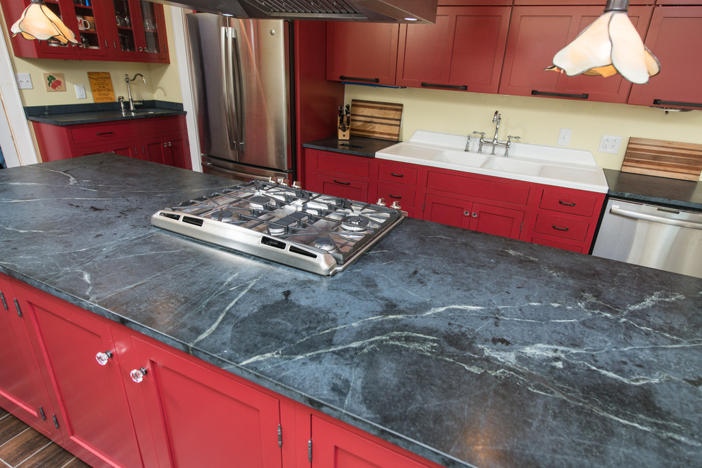 Inspiration for a mid-sized contemporary galley dark wood floor and brown floor eat-in kitchen remodel with a double-bowl sink, raised-panel cabinets, red cabinets, soapstone countertops, stainless steel appliances and an island