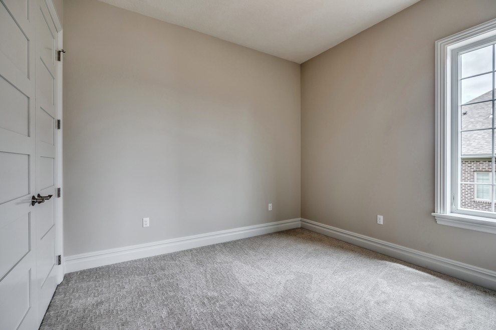 Large transitional master carpeted and gray floor bedroom photo with gray walls