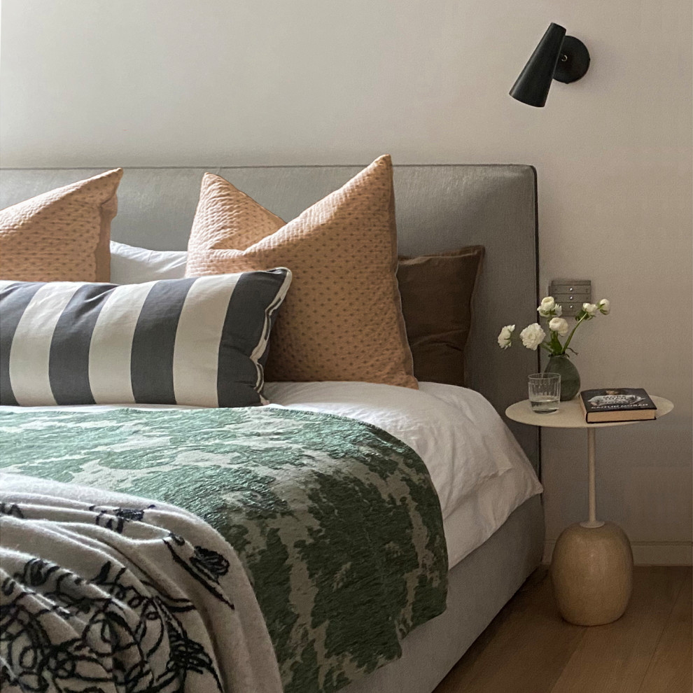 Modelo de dormitorio principal y gris y blanco actual pequeño con paredes blancas, suelo de madera en tonos medios, suelo marrón y bandeja